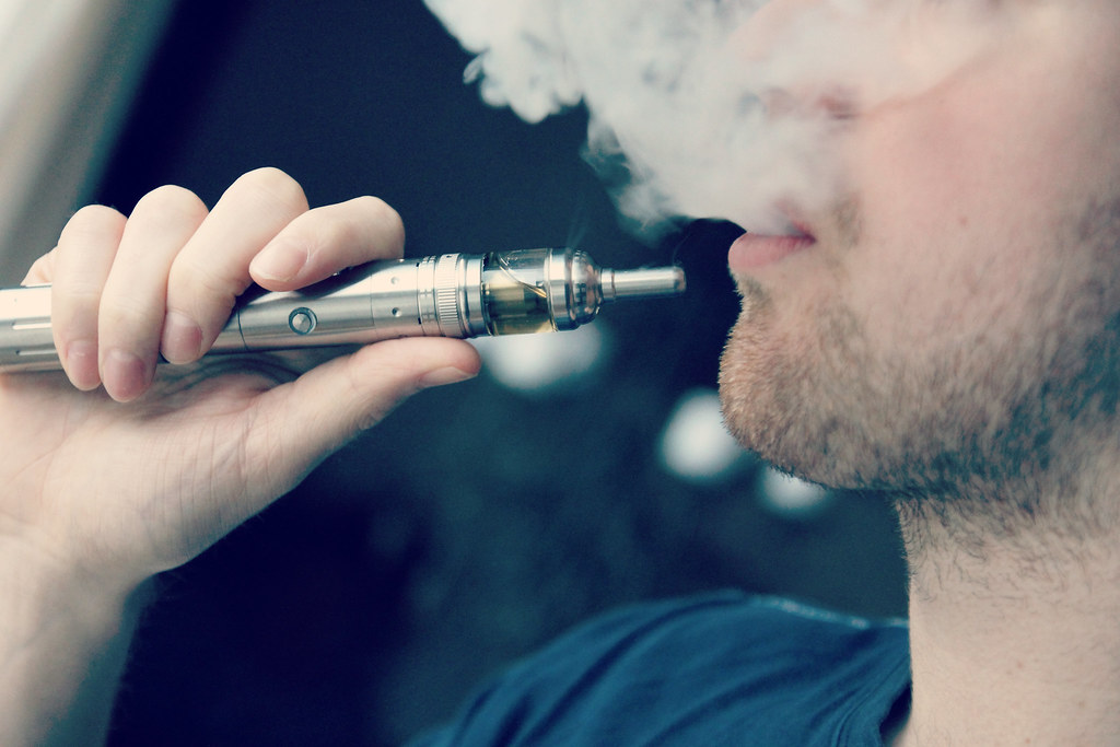 Man exhaling vapor from an e-cigarette